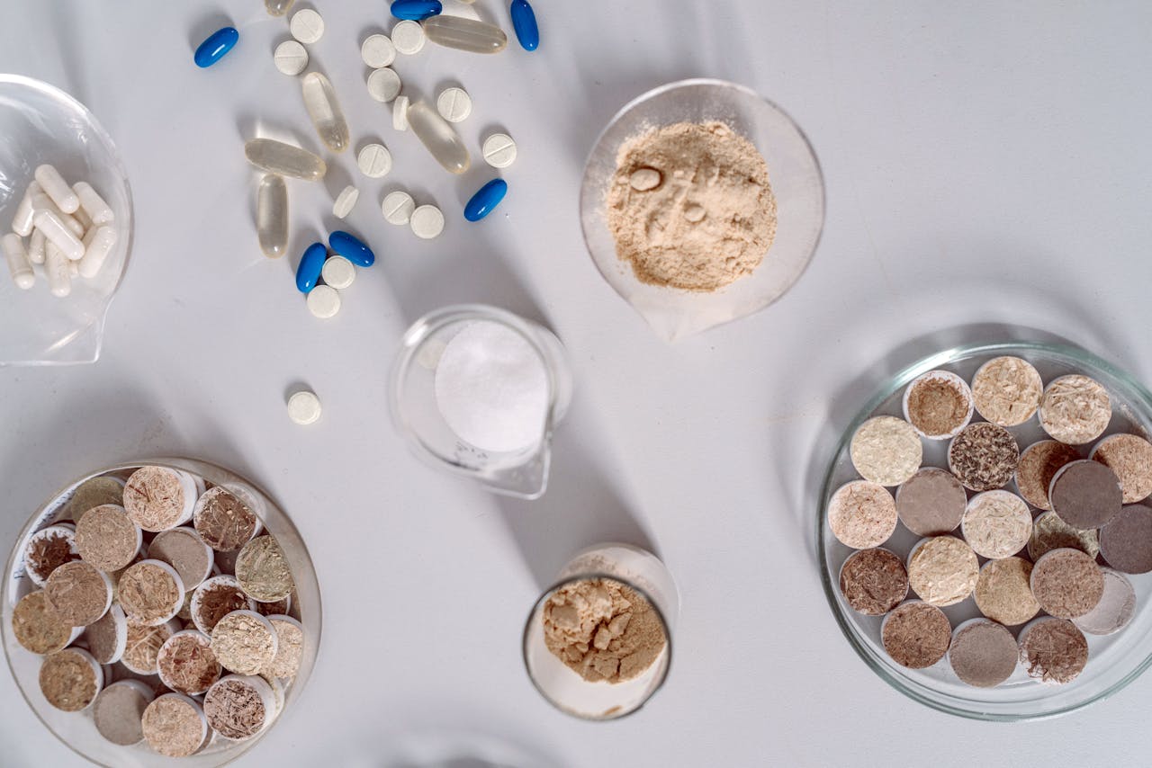 High-angle shot of various pharmaceutical ingredients and pills on a white surface. Ideal for healthcare and science themes.